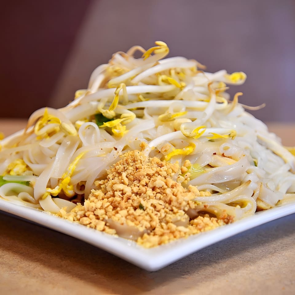 Spicy Bangkok's Pad See Ew with wide rice noodles, bean sprouts, and crushed peanuts.